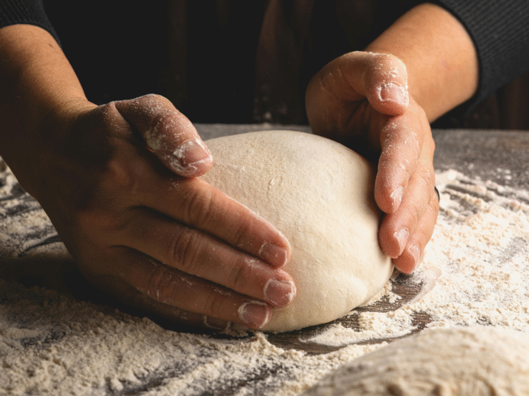 Hands shaping a loaf of sourdough